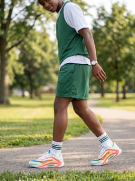 Everlasting – Relaxed mesh basketball shorts in forest green paired with a matching jersey and a white baseball cap for a high-energy streetwear vibe.