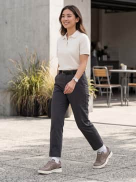 Straight-leg charcoal chinos paired with a tucked-in cream-colored polo and a black leather belt for a sophisticated casual look.