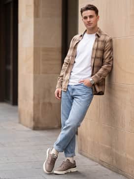 Ex89 – Light-wash tapered denim styled with a basic white t-shirt and an unbuttoned tan flannel shirt for a classic weekend ensemble.
