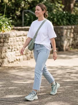 Explore Nitro 2 – A relaxed weekend ensemble consisting of light-wash cropped straight-leg jeans, a white oversized graphic t-shirt, and a sage green crossbody bag.