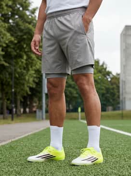 F50 Club Firm Ground  Multi Ground Soccer Cleats – An intensive training ensemble with a grey moisture-wicking compression shirt and matching lightweight running shorts for optimal movement.