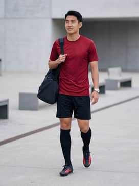 F50 Elite Firm Ground Football Boots – A full team match-day kit featuring a moisture-wicking red jersey, black athletic shorts, and high-performance black compression socks pulled up to the knee.