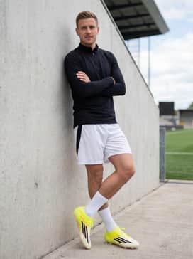 F50 Elite Firm Ground Soccer Cleats – White lightweight mesh soccer shorts paired with a sleek black quarter-zip thermal top for pre-match warm-ups.
