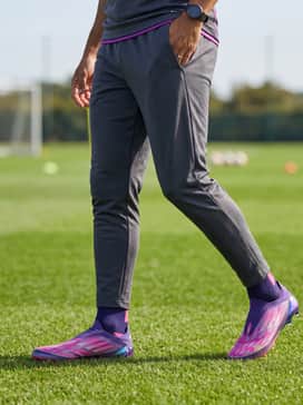 F50 Elite Ly Laceless Firm Ground Cleats – A matching neon pink training jersey paired with charcoal grey moisture-wicking joggers for a coordinated, high-visibility look during intense practice sessions.