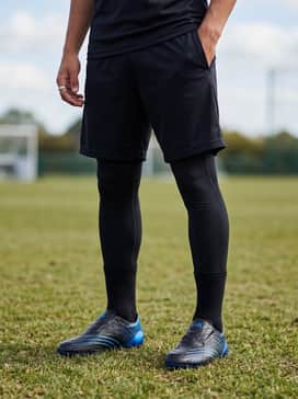 A professional training look featuring black tapered track pants with side stripes, a matching quarter-zip tech top, and a lightweight training gilet for cooler morning sessions.