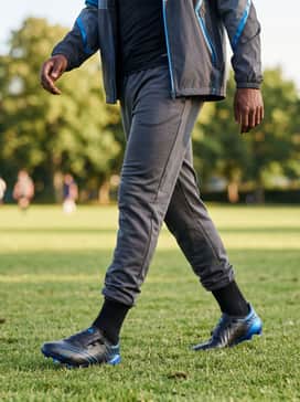 F50 Elite Spider Firm Ground Cleats – A streamlined pre-match outfit with charcoal joggers, a compression base-layer shirt, and a sleek waterproof windbreaker for warm-ups in variable weather.