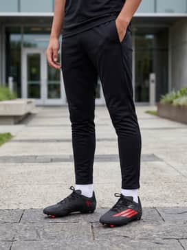 F50 League Firm Ground  Multi Ground Soccer Boots Kids – A sleek training outfit consisting of black slim-fit track pants, a lightweight grey quarter-zip training top, and white crew socks.