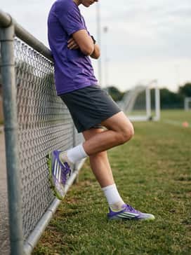 F50 League Firmmultiground Cleats Kids – A purple graphic athletic shirt and breathable mesh shorts in a neutral charcoal grey to let the vibrant colors of the cleats pop on the field.