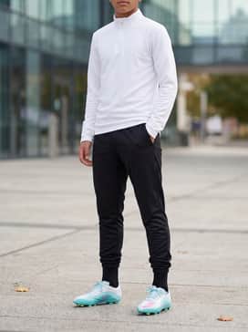 F50 Messi League Firm Ground Multi Ground Football Boots Kids – Black moisture-wicking joggers paired with a sleek white quarter-zip training top and professional-grade soccer socks for a focused practice look.
