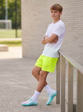 F50 Messi League Firm Ground Multi Ground Football Boots Kids – Vibrant neon yellow mesh shorts and a breathable white performance t-shirt that highlights the bright accent colors found on the cleats.