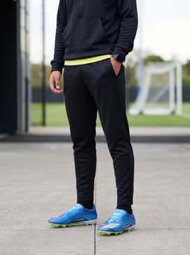 F50 Messi Pro Firm Ground Cleats – A training look consisting of tapered black track pants, a moisture-wicking quarter-zip hoodie, and a matching neon sweatband.