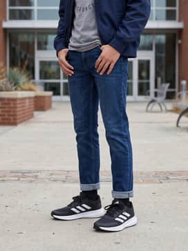 Falcon 3 Sport Lace Shoes – An effortless casual outfit for school consisting of tapered dark-wash denim jeans, a heather grey graphic t-shirt, and a classic navy blue bomber jacket.