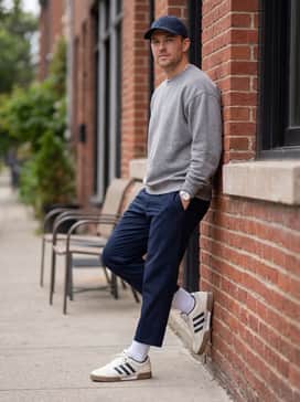 Fechten Indoor Consortium Shoes – Navy blue cropped trousers with white athletic socks and a grey oversized sweatshirt for a clean, contemporary streetwear look.