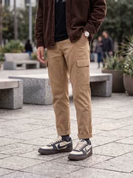 Tan cargo pants and a black graphic tee layered under a chocolate brown corduroy shirt jacket to highlight the earthy midsole.