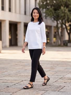 Dark wash capri jeans paired with a crisp white linen tunic and a minimalist silver necklace for a clean, nautical-inspired casual look.