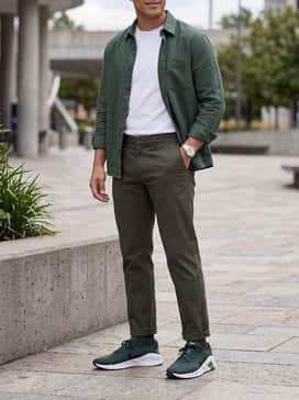 Slim-fit dark indigo jeans with a crisp white crewneck t-shirt and an unbuttoned olive green overshirt for a relaxed, layered weekend look.