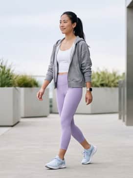 High-waisted lavender leggings paired with a white moisture-wicking cropped tank and a grey oversized zip-up hoodie for a coordinated workout-to-coffee look.