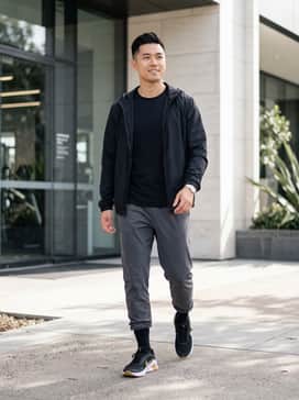 A sleek pair of tapered black joggers paired with a moisture-wicking charcoal grey t-shirt and a matching lightweight windbreaker for a complete gym-ready look.