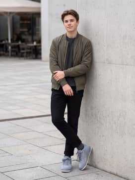Flight Court – Slim-fit black chinos combined with a dark grey waffle-knit crewneck sweater and an olive green bomber jacket for a sophisticated, high-low casual ensemble.