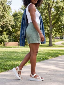 Sage green utility shorts worn with a simple white ribbed tank top and an oversized denim jacket for a day of sightseeing.
