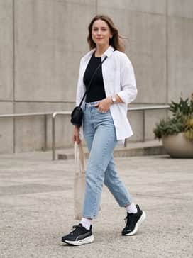 Casual weekend errand outfit: Style with light-wash cropped straight-leg jeans, a crisp white oversized button-down shirt worn open over a black bodysuit, and minimalist silver jewelry.