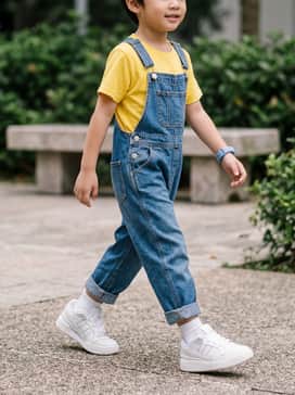 Forum Low Cl Shoes Kids – Classic denim overalls worn over a bright primary-colored cotton t-shirt for a timeless playground look.