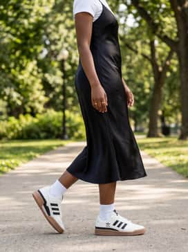Forum Low Shoes – A black midi-length slip dress layered over a white fitted short-sleeve t-shirt with dainty gold jewelry for a 90s-inspired feminine contrast.
