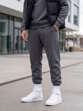 Forum Mid Shoes – Tapered charcoal grey joggers and a matching tech-fleece hoodie under a black puffer vest for a clean, athletic-inspired urban look.