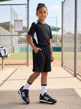 An athletic training outfit featuring a moisture-wicking black performance t-shirt and breathable mesh shorts for drills at the diamond.