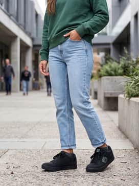 Freerider Mountain Bike Shoes – Mid-wash straight-leg jeans with a cuffed hem, worn with an oversized graphic sweatshirt in a neutral tone to highlight the shoe's mint accents.