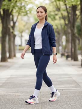 A performance-driven look featuring navy blue high-compression leggings, a white moisture-wicking tank top, and a lightweight navy windbreaker.