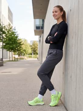 Charcoal grey oversized joggers and a fitted black long-sleeve technical top, creating a comfortable yet edgy athleisure vibe suitable for both light training and casual errands.