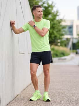 Five-inch inseam black athletic split shorts worn with a matching neon green performance tee for a bold, coordinated speed-training look.