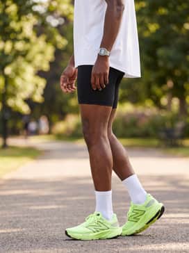 Fresh Foam X Balos V1 – Relaxed black athletic shorts paired with a crisp white oversized moisture-wicking t-shirt and a black performance baseball cap for a post-workout cool down.