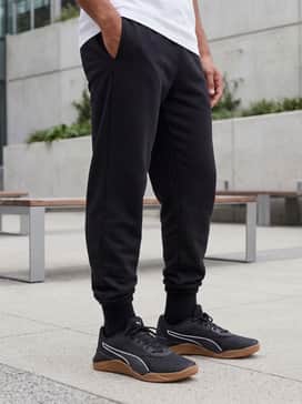 A trendy streetwear outfit consisting of slim-fit black denim, an oversized white graphic tee, and a neutral-toned bomber jacket for a sharp urban aesthetic.
