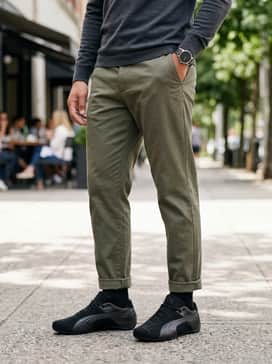 Future Cat Emboss Mens Sneakers – A sophisticated smart-casual ensemble with tapered olive green chinos, a black long-sleeve polo shirt, and a minimalist black leather watch to complement the shoe's textures.