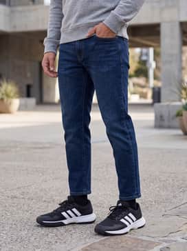 Gamecourt 2 Tennis Shoes – An effortless casual outfit pairing tapered dark-wash indigo jeans with a grey heathered hoodie and a black baseball cap.