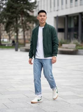 Gato – A pair of wide-leg light-wash denim jeans, a white boxy-fit graphic tee, and a pine green varsity jacket to highlight the shoe's primary accent color.