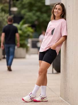 Gelchallenger 15 – Black moisture-wicking biker shorts paired with a loose-fitting graphic t-shirt in a pastel color and tall white crew socks to lean into the retro-athletic aesthetic.