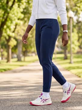 Gelchallenger 15 – Navy blue slim-fit joggers with a white cropped zip-up hoodie and a sleek ponytail for a clean, sporty ensemble perfect for running errands or grabbing coffee.