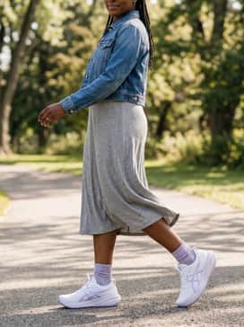 A heather grey ribbed jersey midi dress layered under a cropped denim jacket to balance performance comfort with feminine street style.
