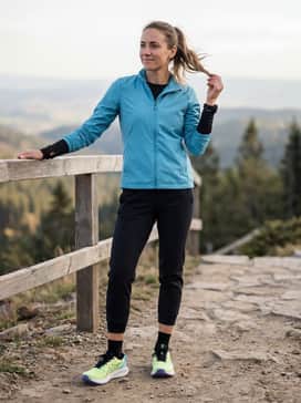 Tapered black joggers and a sleek, weather-resistant windbreaker in a matching cyan blue for a coordinated athletic look suited for cool-weather training.