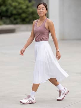Gelgame Ff Padel – A white pleated athletic skirt paired with a mauve-toned moisture-wicking racerback tank for a professional on-court look.