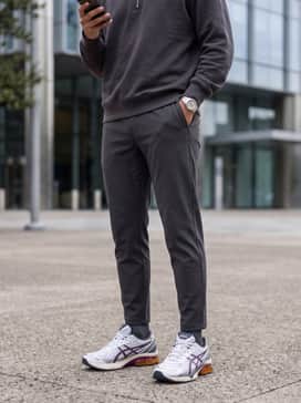 Black tapered joggers with a sleek charcoal quarter-zip sweatshirt for a modern, monochromatic athletic look that makes the amber heel pop.