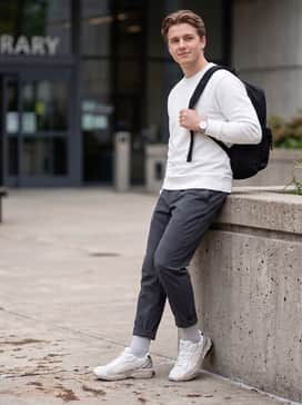 Gelkinetic Fluent – Dark charcoal tapered joggers worn with a matching grey hoodie and a metallic silver crossbody bag to highlight the shoe's hardware.