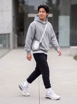 Gelkinetic Fluent – An oversized heather grey hoodie paired with black nylon joggers and a silver metallic crossbody bag for a cohesive Y2K-inspired streetwear look.