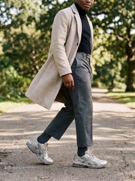 Gelnimbus 101 – Cropped charcoal tailored trousers, a tucked-in black turtleneck, and an oversized wool overcoat in oatmeal to contrast the sporty tech-runner with sophisticated urban wear.