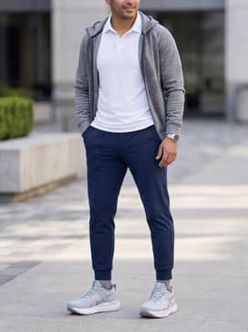 Gelnimbus 28 Atc – Clean athleisure ensemble featuring navy blue tapered joggers, a crisp white performance polo, and a matching grey tech-fleece hoodie.