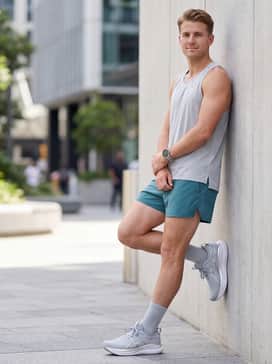 Summer fitness outfit consisting of teal split running shorts and a light grey perforated singlet for maximum breathability during outdoor workouts.