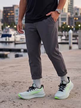 Gelnimbus 28 Extra Wide – A sleek athleisure outfit with charcoal grey tapered tech joggers, a matte black hoodie, and a technical baseball cap.